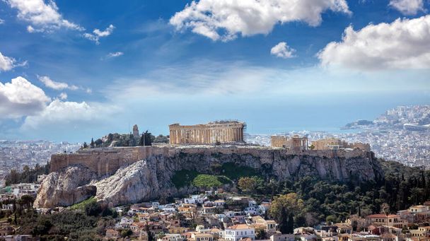 Atenas, Grecia. Acrópolis y templo de Partenón. Antiguos restos, vista aérea desde Lycabettus Hill. Paisaje urbano, mar azul y cielo nublado - Foto, Imagen