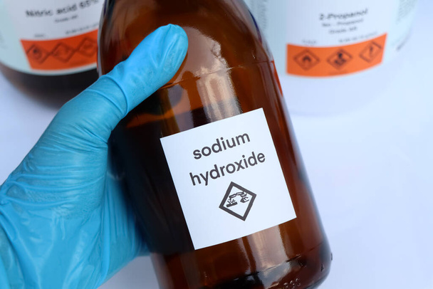 Sodium hydroxide in bottle, chemical in the laboratory and industry - Photo, Image