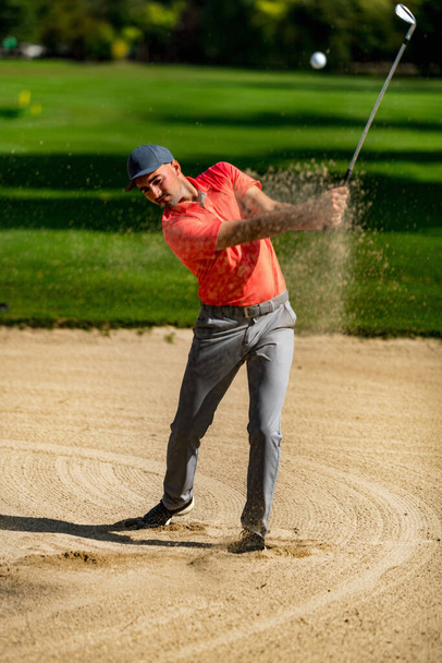 Golf sparato dalla sabbia, giocatore di golf professionista che gioca da un bunker di sabbia, pallina da golf in aria - Foto, immagini