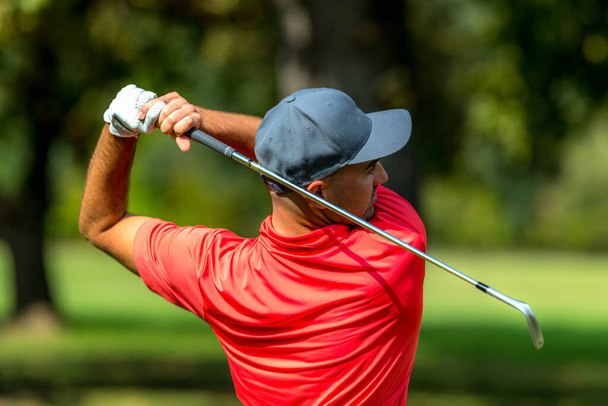 Golf swing rear view. Professional golfer finishing a golf swing - Foto, Imagen