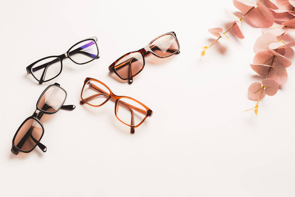 Several trendy stylish glasses on white background with copy space. Optics, shop of glasses and frames concept. - Foto, imagen