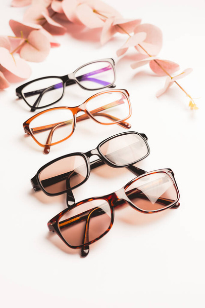 Varias gafas elegantes de moda sobre fondo blanco con espacio para copiar. Óptica, tienda de gafas y monturas concepto. - Foto, Imagen