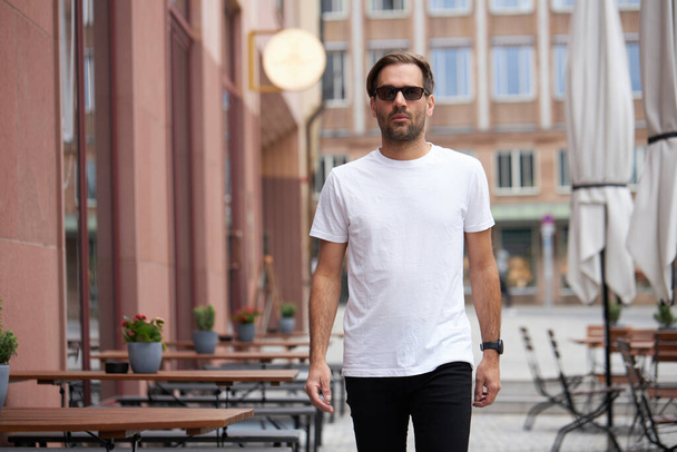 Fehér üres póló egy hipster jóképű férfi modell hely a logó vagy design alkalmi városi stílusban - Fotó, kép