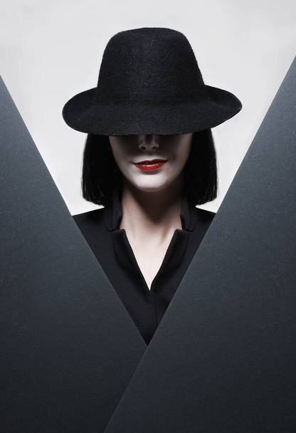 私から隠れることができる秘密はない。灰色の背景に帽子をかぶった謎の女性のスタジオショット. - 写真・画像