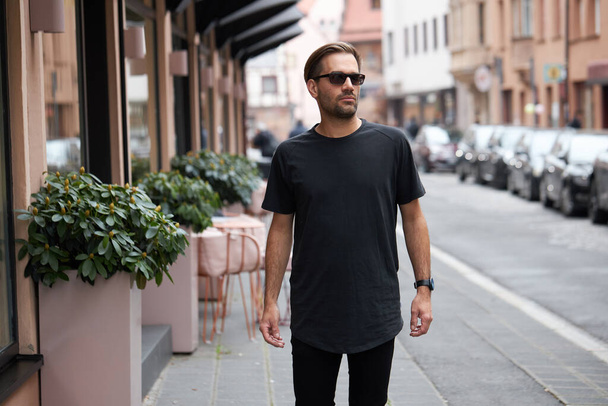 Black blank t-shirt on a hipster handsome male model with space for your logo or design in casual urban style - Фото, зображення