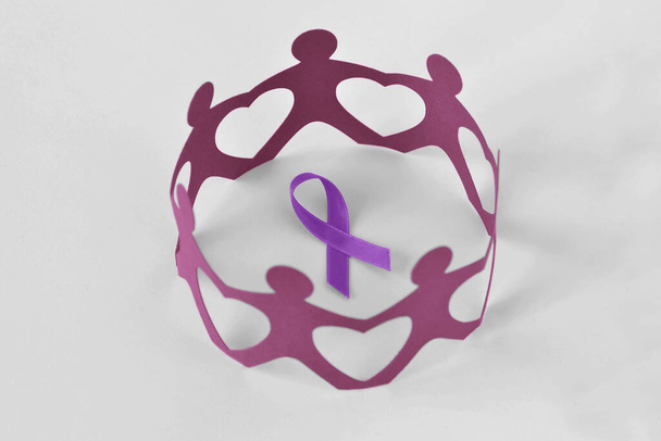 Papieren mensen in een cirkel rond violet lint op witte achtergrond - Concept van huiselijk geweld bewustzijn; ziekte van Alzheimer, alvleesklierkanker, epilepsie bewustzijn en lymfoom van Hodgkin - Foto, afbeelding