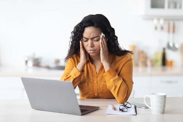 Black lady freelancer suffering from headache while working - Fotoğraf, Görsel