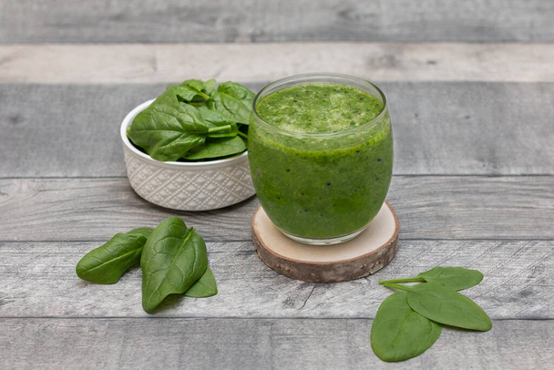 Spinach smoothie. Healthy dieting and nutrition, food and drink, vegan, vegetarian concept, healthy lifestyle. Green smoothie with organic ingredients, vegetables on a wooden table.  - Фото, зображення