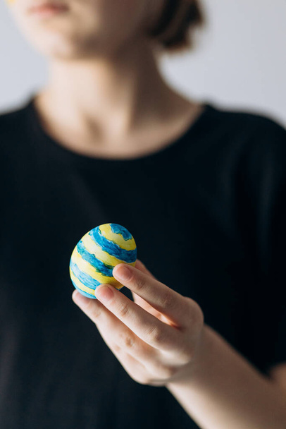 Ukrainian girl holds painted pysanka egg. Easter Egg - Фото, изображение