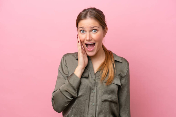 Young caucasian woman isolated on pink background with surprise and shocked facial expression - Foto, Imagen