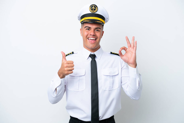 Пілот літака кавказький чоловік ізольований на білому тлі, показуючи знак ок і жест великого пальця вгору
 - Фото, зображення