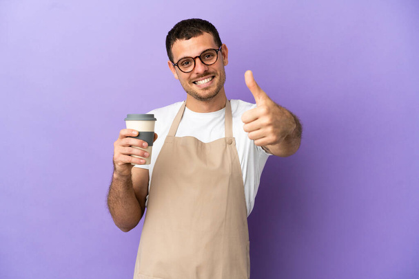 Brazilian restaurant waiter over isolated purple background with thumbs up because something good has happened - 写真・画像