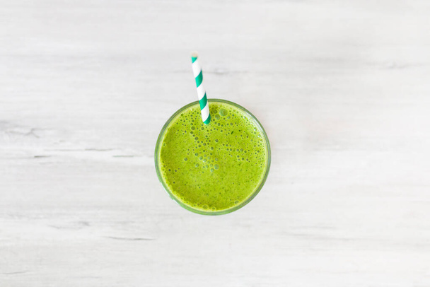 Gezonde groene smoothie met spinazie en avocado op houten tafel  - Foto, afbeelding