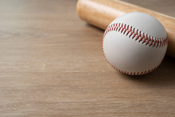 Close up baseball and baseball bat on wooden table background, sport concept - Valokuva, kuva