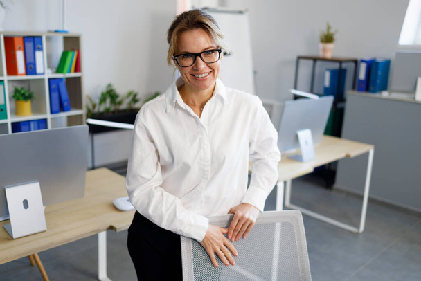 Hymyilevä kypsä liiketoiminnan nainen toimistossa - Valokuva, kuva
