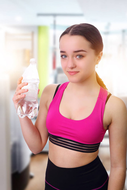 beautiful and young girl after fitness workout with bottle of water - Foto, imagen
