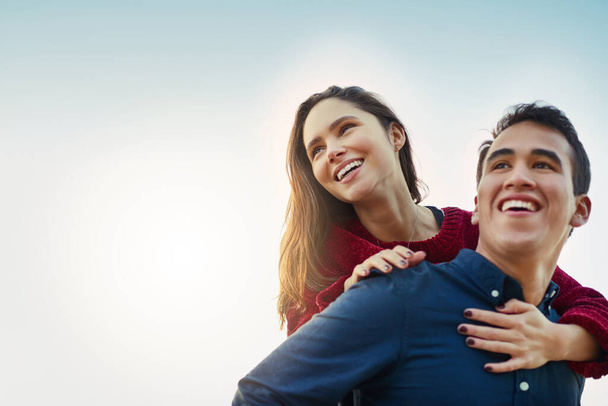 O amor ilumina-se a qualquer dia. Tiro de um jovem casal feliz desfrutando de um passeio de piggyback ao ar livre. - Foto, Imagem