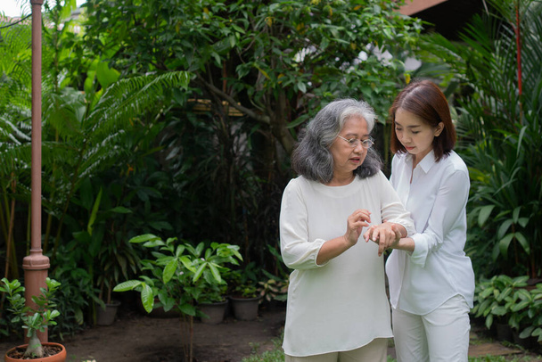 Stará Asiatka a procházela se na dvorku se svou dcerou. Koncept šťastného odchodu do důchodu S péčí pečovatele a spořitelen a seniorského zdravotního pojištění, Happy family - Fotografie, Obrázek