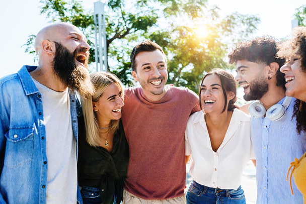 Gruppe lächelnder junger Freunde amüsiert sich gemeinsam im Freien - Foto, Bild