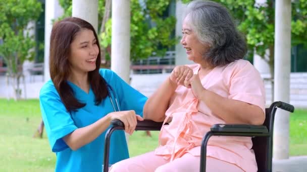 Asiatico attento caregiver o infermiere prendersi cura del paziente asiatico anziani in sedia a rotelle. Concetto di felice pensionamento con cura da un caregiver e risparmio e l'assicurazione sanitaria senior. assistenza agli anziani - Filmati, video