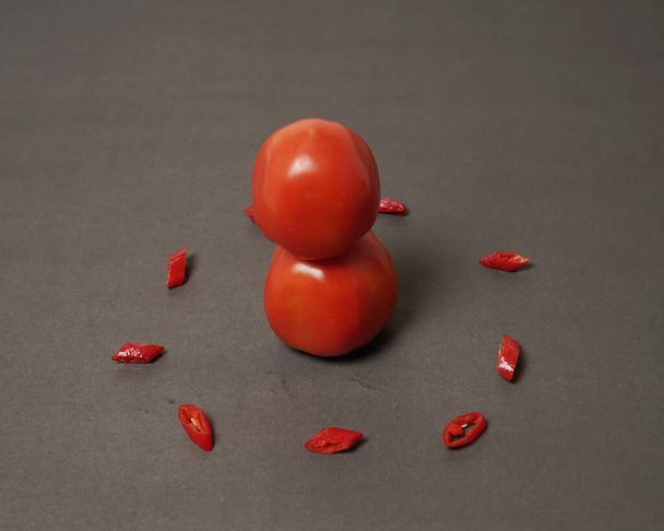 De combinatie van verse tomaten, rode pepers en eieren vormt een glimlachend gezicht. Koken ingrediënten klaar om te worden geserveerd. focus wazig, achtergrond inspiratie. zwart-rode kleurencombinatie. - Foto, afbeelding