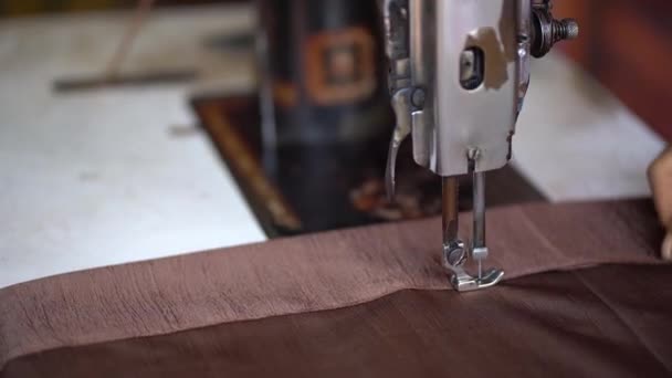 A closeup of view of a manual stitching machine sewing brown cloth. - Felvétel, videó