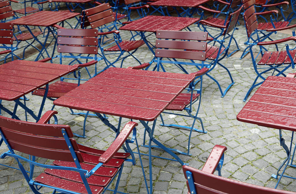 many wet chairs and tables of the alfresco cafe after rain without people - Photo, Image
