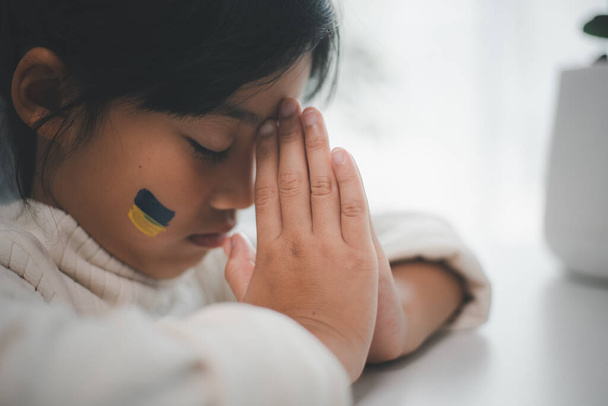 A child with the flag of Ukraine is crying. Sadness longing hope. Children's tears from the war. Evacuation of civilians. Freedom to Ukraine - Foto, Imagem