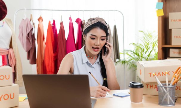 Entrepreneur Asian young woman sell clothes check order product working at home. start-up small business owner, SME or freelance business online and delivery concept. - Photo, Image