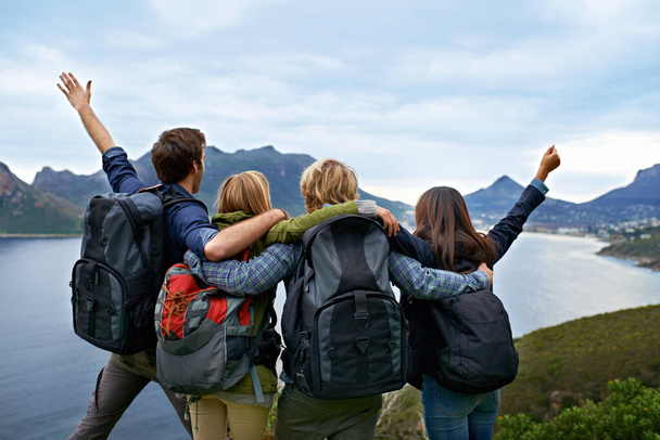 Woohoo This is the most awesome holiday ever. A group of young people admiring the view together. - Foto, imagen