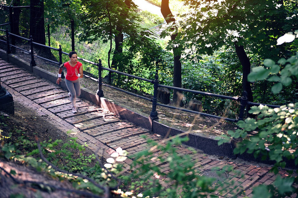 Yleisnäkymä keski-ikäisestä urheilijasta juoksemassa portaissa puiston kaiteella. Sydänharjoitus, lenkkeily, aktiivinen ja terveellinen elämäntapa käsite - Valokuva, kuva