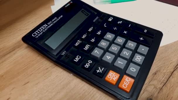 Чорний калькулятор лежить на робочому столі. Звіт або підрахунок, робочі моменти
. - Кадри, відео