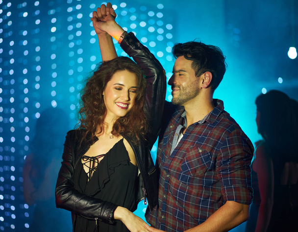Aşkın ritmiyle dans etmek. Sevecen genç bir çiftin bir gece kulübünde dans edişinin fotoğrafı.. - Fotoğraf, Görsel