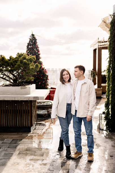 kaunis pari rakastunut poseeraa koristeltu jouluksi parveke modernissa talossa  - Valokuva, kuva