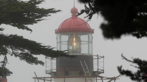 古い灯台フレネルレンズ輝く、霧の多い雨の天気。照光式ビーコンUSA - 写真・画像