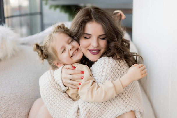 portrait of beautiful young woman hugging her little daughter  - Fotografie, Obrázek