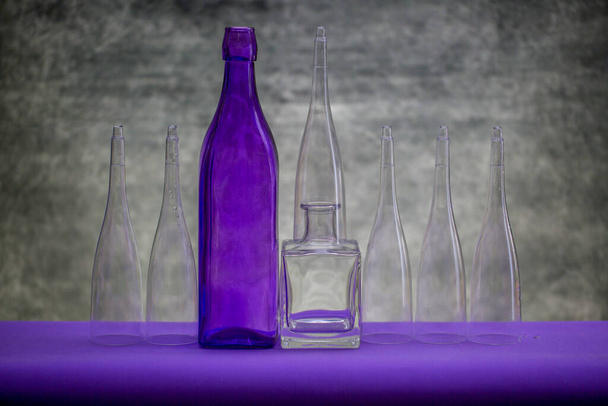 Натюрморт зі скляним посудом на фіолетовому столі
 - Фото, зображення