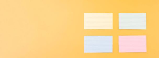 quatro papéis de escrita em branco sobre um fundo amarelo. espaço para texto - Foto, Imagem