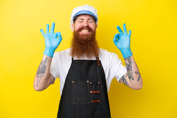 Fishmonger wearing an apron isolated on yellow background in zen pose - Foto, imagen