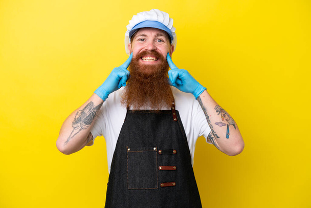 Fishmonger wearing an apron isolated on yellow background smiling with a happy and pleasant expression - Foto, imagen