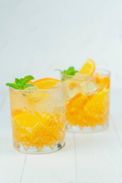 delicious refreshing cocktail drink with alcohol and orange with mint leaf - Photo, Image