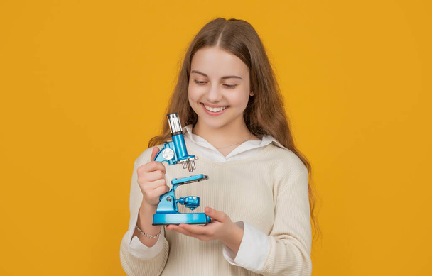 positive child with microscope on yellow background - Foto, imagen