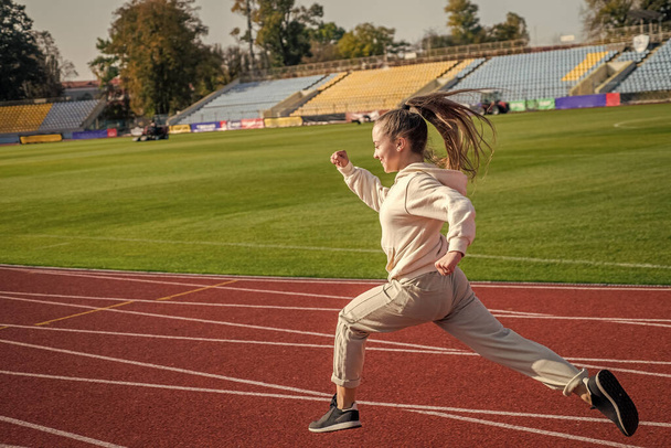 The rule in running is just run. Energetic girl run on running track. Sports school - Foto, Imagem