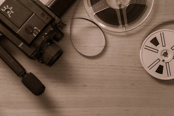 Old 8 mm video camera with film reels on wooden background. Copy space. Selective focus. - Foto, immagini