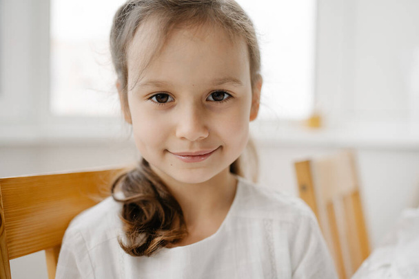 Portrait of adorable brown-haired girl wearing white blose - Foto, immagini