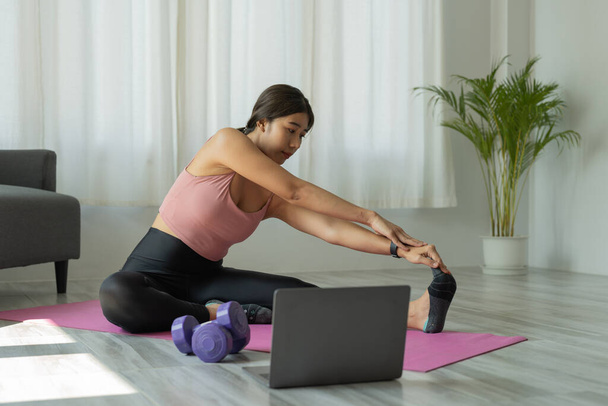 Młoda kobieta ćwiczy jogę w domu. Fitness, trening, zdrowe życie i koncepcja diety - Zdjęcie, obraz