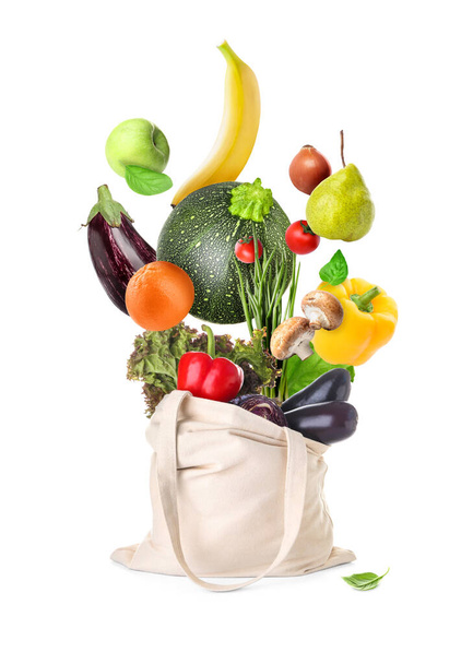 Shopping bag with flying fresh vegetables and fruits on white background - Foto, Imagen