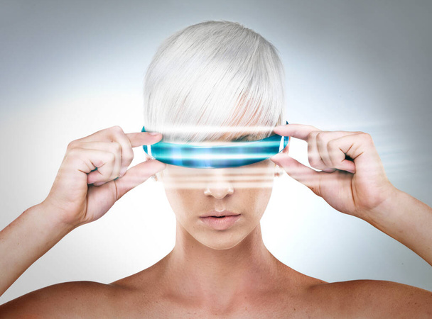 Envisioning the future. A futuristic view of a young woman with glasses. - Foto, Imagen