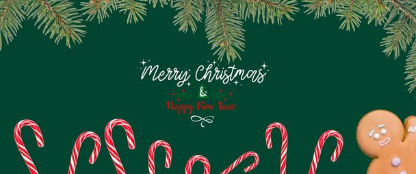 Beautiful greeting card for Merry Christmas and Happy New Year celebration with fir tree branches, candy canes with gingerbread - Photo, Image