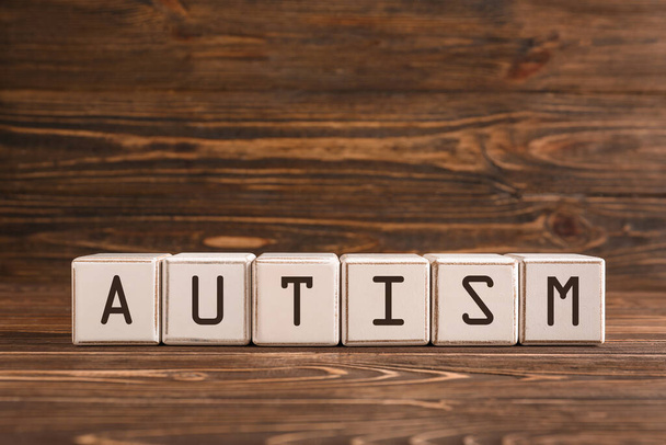 Word AUTISM made of cubes on wooden background - Photo, image
